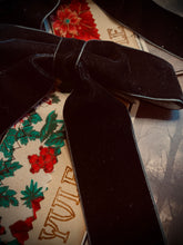 Load image into Gallery viewer, Black velvet ribbon on a floral-patterned fabric background